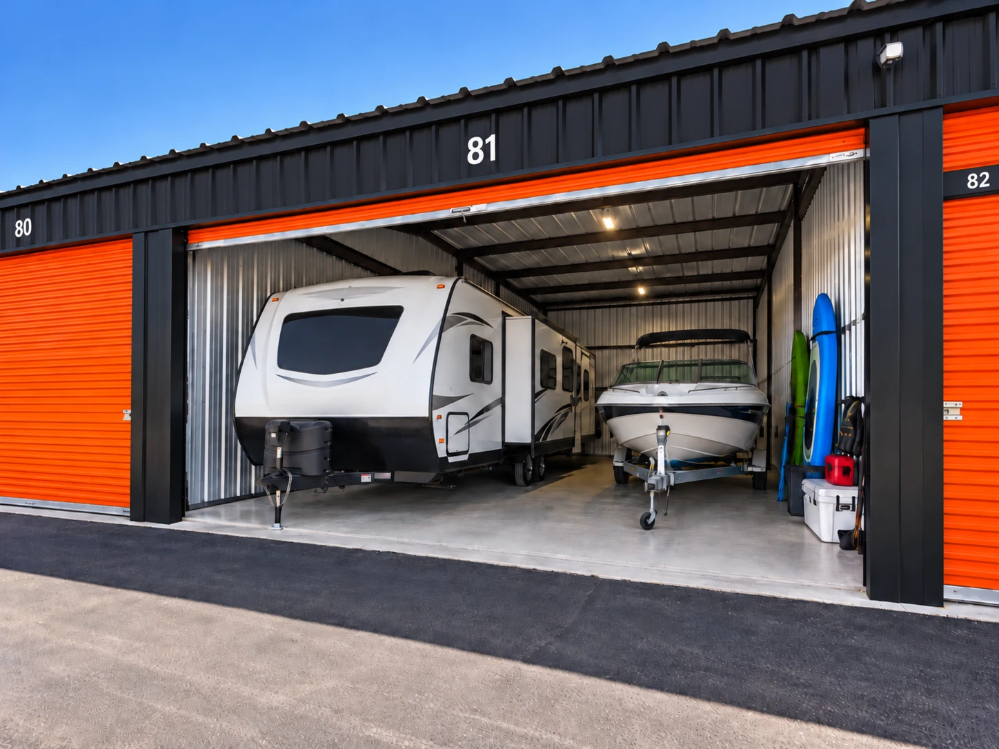 RV camper, boat and kayaks stored in a large drive-up storage unit