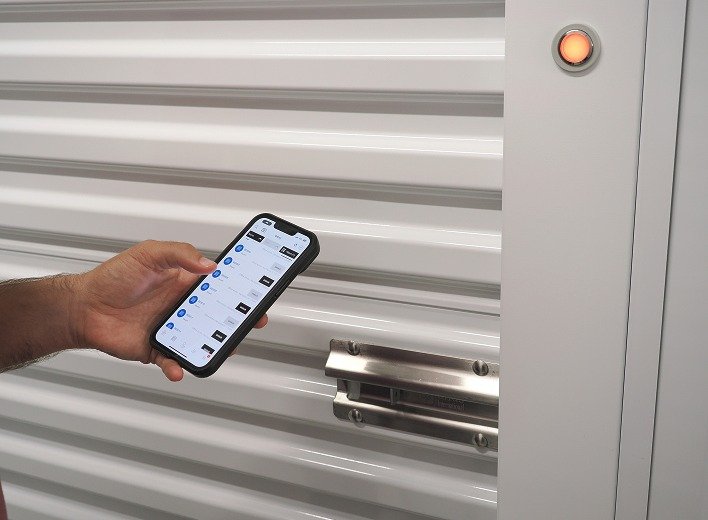 A hand holding the phone up to the unit door